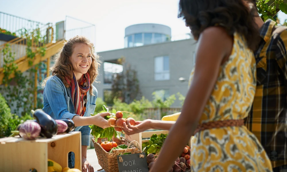 Woman purchasing vegetables at a farmers market