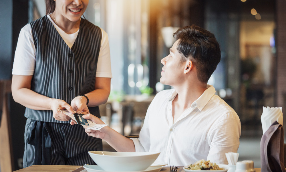 Waitress presenting the bill to a customer